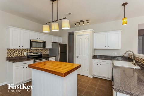 A kitchen with a wooden island in the middle.