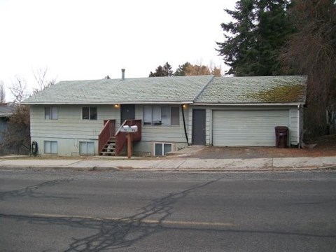 A house with a grey roof and a red door.