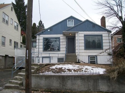 a white and blue house with a snowy yard