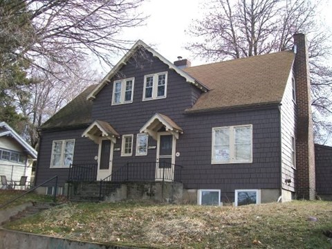 a house with black siding on a hill
