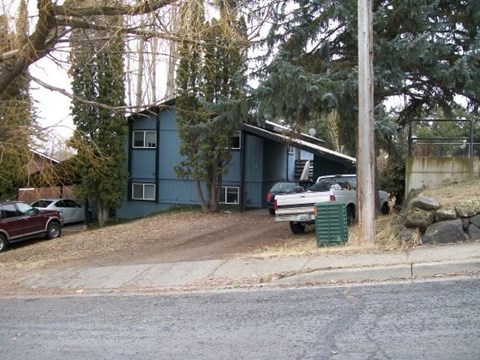 A blue house with a car parked in front.