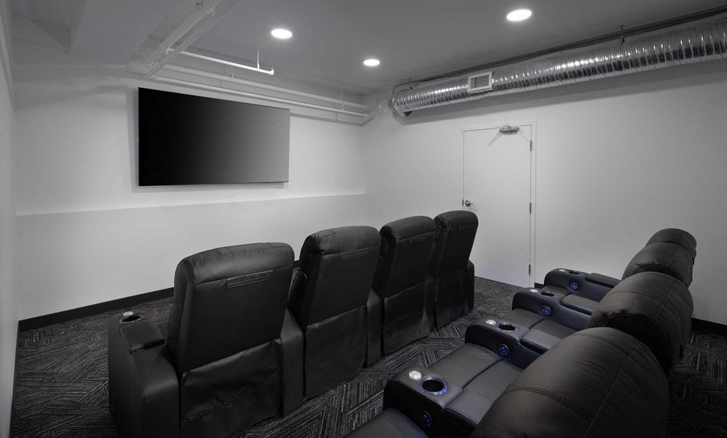 a small room with a row of chairs and a television