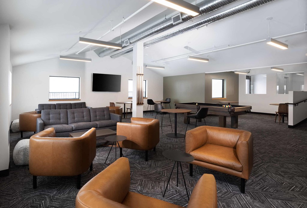 a lounge room with couches and chairs and a pool table