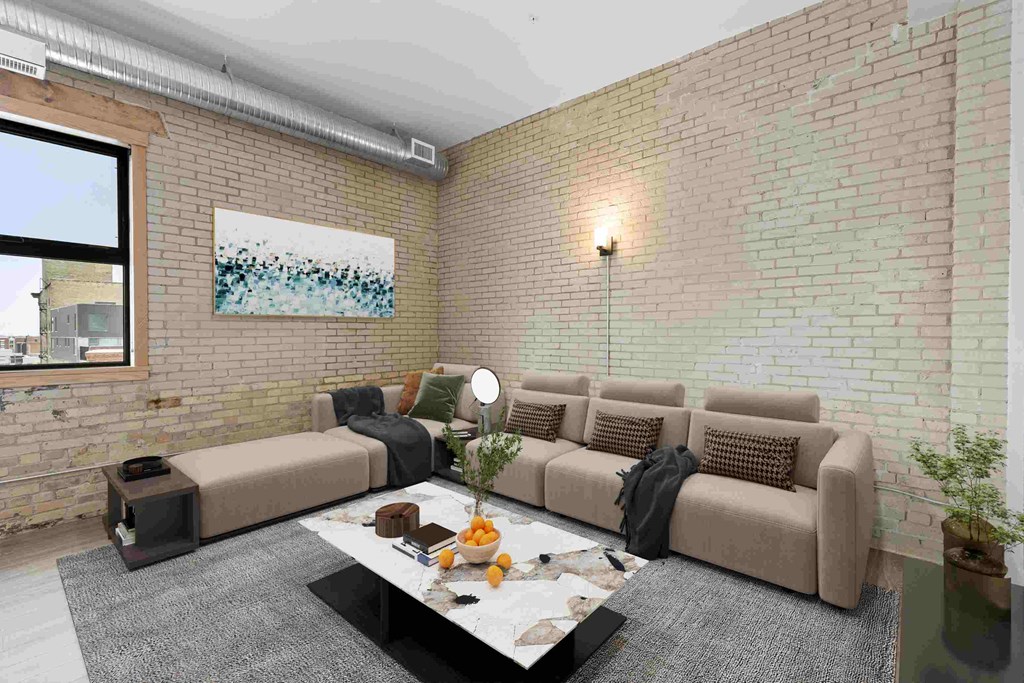 a living room with exposed brick walls and a large couch