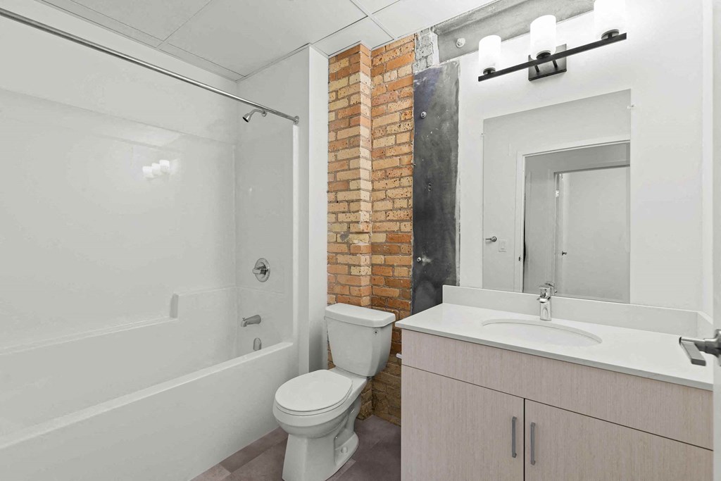 a bathroom with a toilet and a sink and a shower
