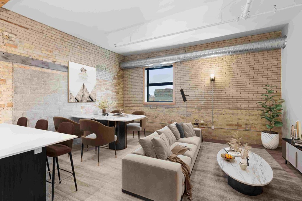 a living room with exposed brick walls and a long couch
