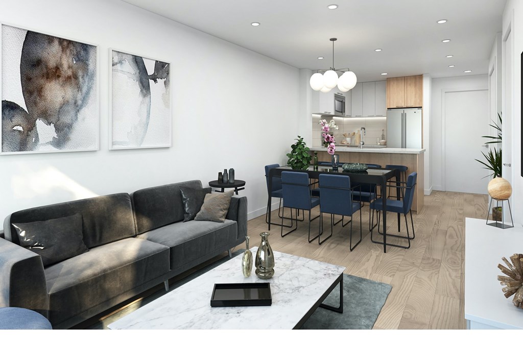 A modern living room with a grey sofa and a dining table set up.