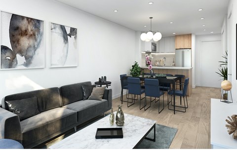 A modern living room with a grey sofa and a dining table set up.