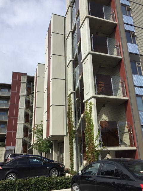 A black car is parked in front of a tall building.