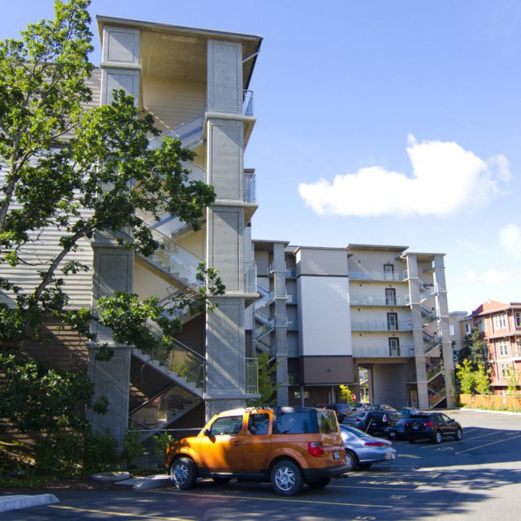 A car is parked in a parking lot in front of a building.