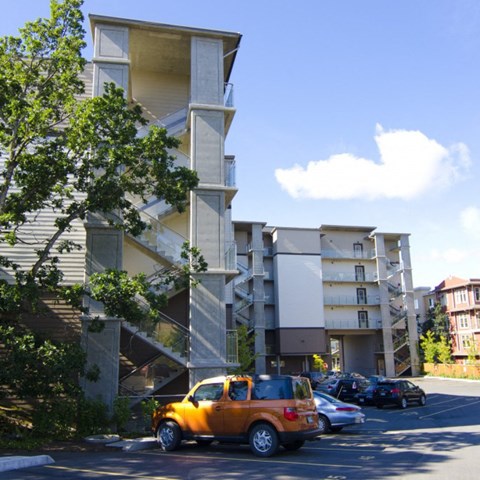 A car is parked in a parking lot in front of a building.