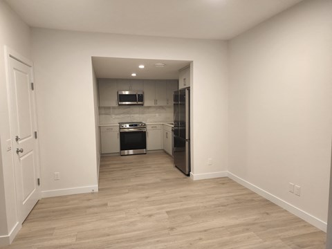 a renovated kitchen with white walls and wood flooring