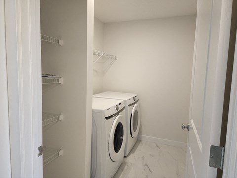 a white washer and dryer in a white laundry room