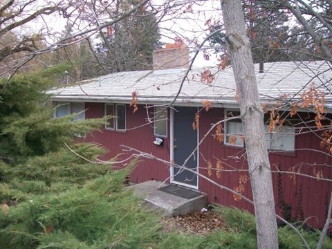 A red house with a grey roof and a grey door.