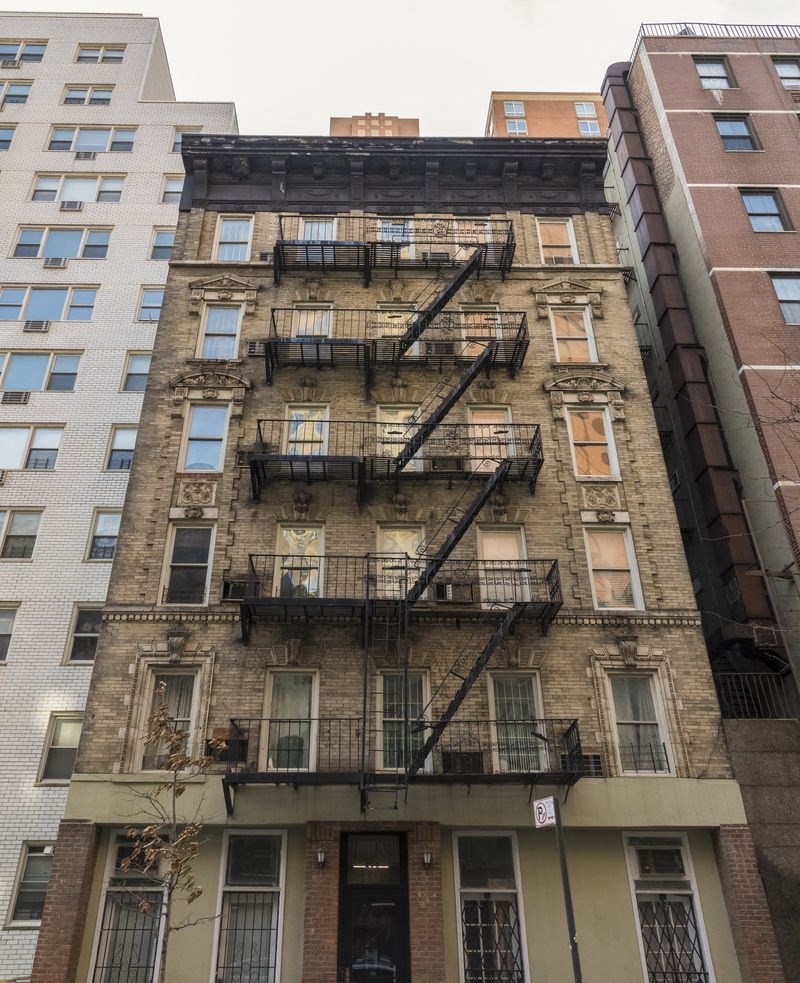 the facade of a brick building with fire escapes