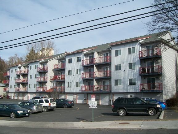 an apartment building with cars parked in front of it