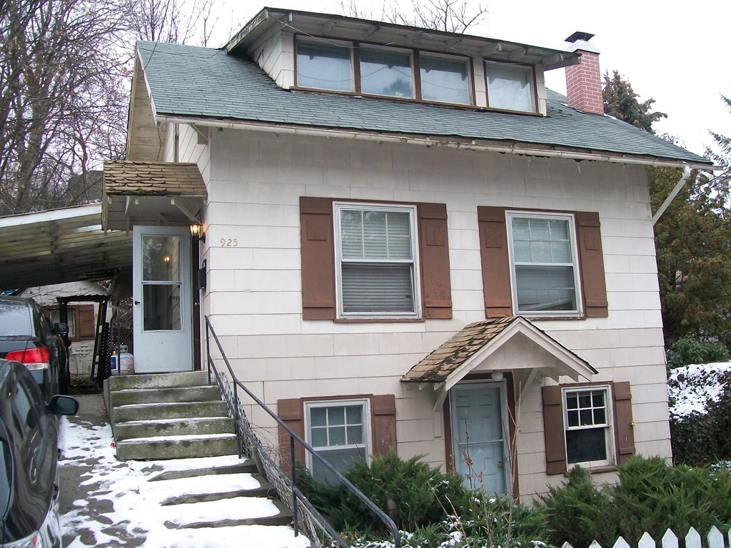 A house with a white door and brown shutters.