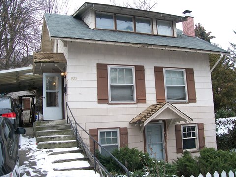 A house with a white door and brown shutters.