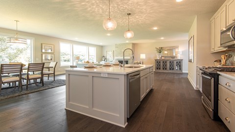 A modern kitchen with white cabinets and a large island.