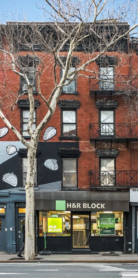 a large brick building with a tree in front of it