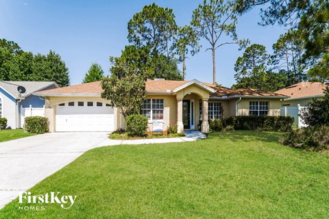 a suburban house with a lawn and a white garage door