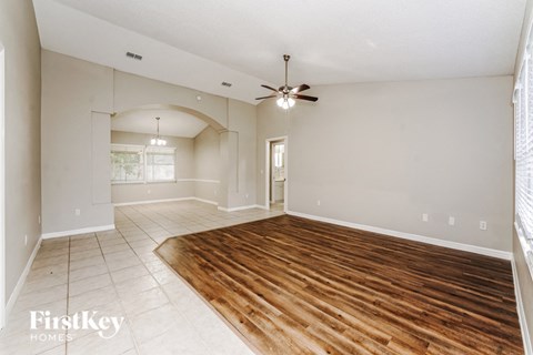 a living room with a wooden floor and a ceiling fan