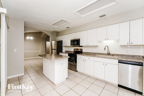a large kitchen with white cabinets and black appliances