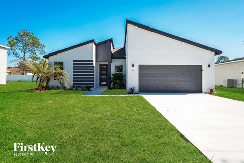A modern house with a white exterior and a black roof is for sale by FirstKey Homes.