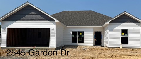 a new house with a garage and a dirt