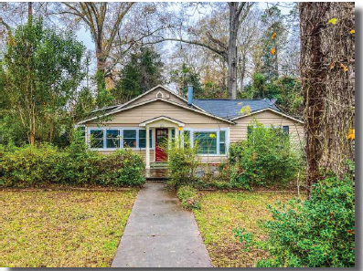 the front of a house with trees and a sidewalk