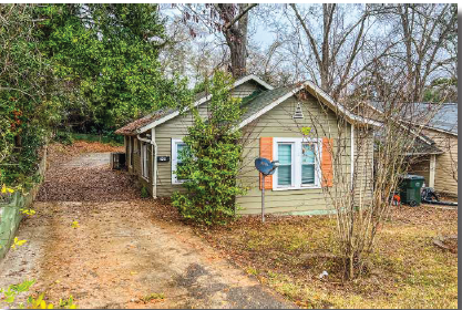 a small house on the side of a dirt road