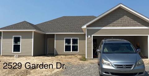 A silver Honda Civic is parked in front of a house.