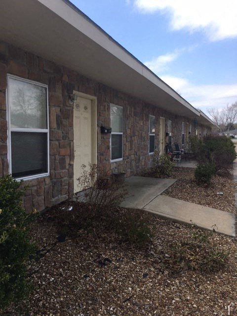 a brick building with a white door and a sidewalk