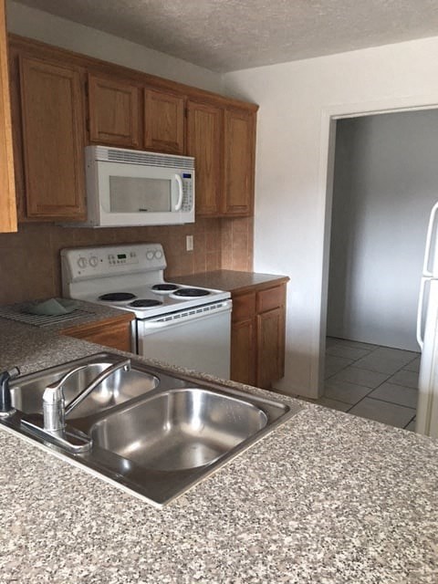 a kitchen with a sink and a stove and a microwave