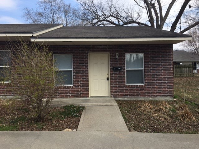 a small brick house with a white door