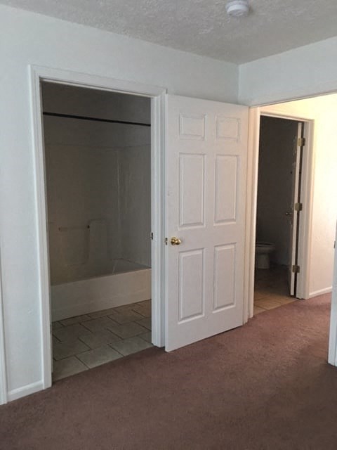 an empty room with a door open to a bathroom