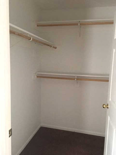 a small room with a white wall and a white closet