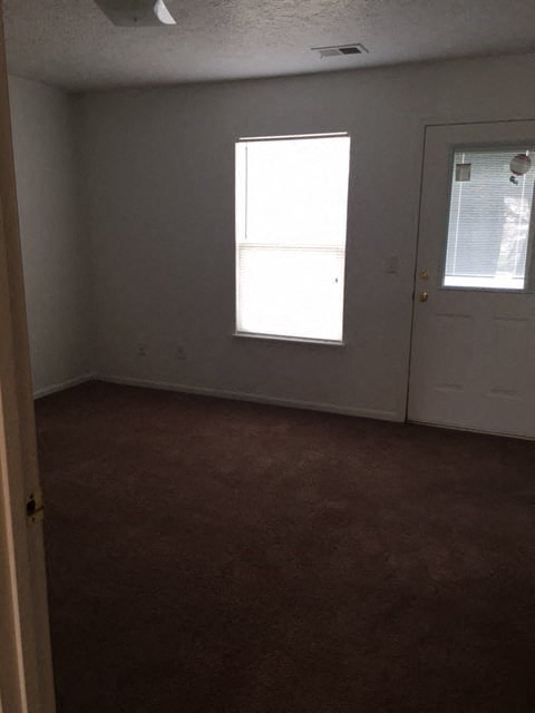 an empty room with a door and a window