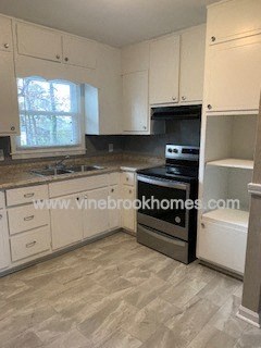 A kitchen with a stove top oven and a sink.