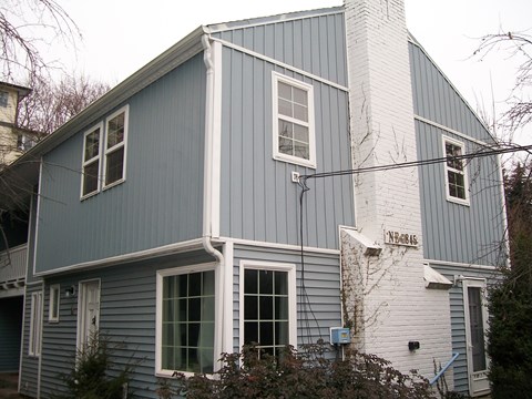 the outside of a house with blue siding and white bricks