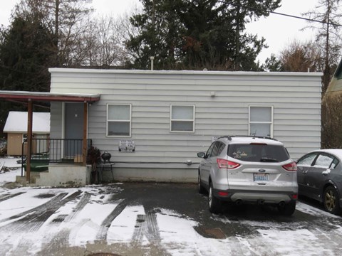 a mobile home with a car parked in front of it