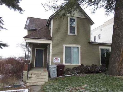 a yellow house with a sign on the front of it