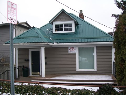 A house with a green roof and a sign that says "No Parking".