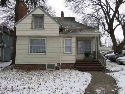 a yellow house with snow on the ground