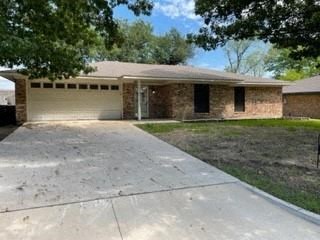 a small brick house with a driveway in front of it