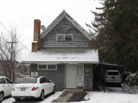 A house with a car parked in front of it.