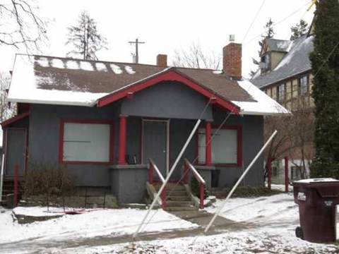 A house with a red roof and a brown chimney.