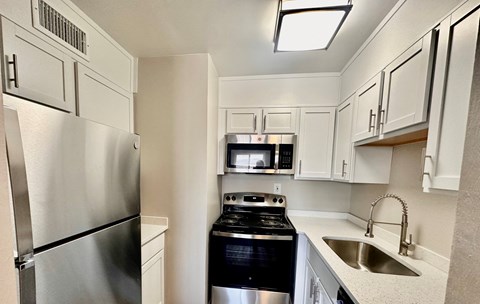 a kitchen with stainless steel appliances and white cabinets