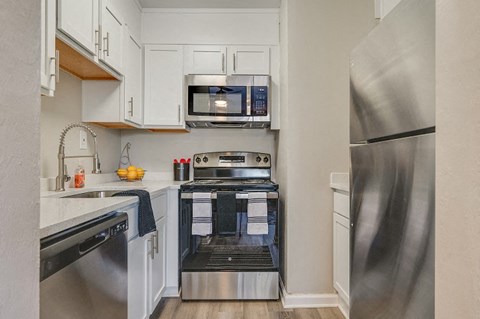 a kitchen with stainless steel appliances and white cabinets
