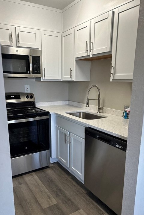 a kitchen with stainless steel appliances and white cabinets